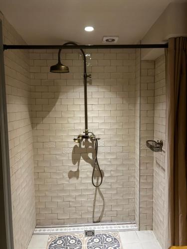 a shower with a light on the wall at Uzupis Angel 3 bedroom Apartment in Vilnius