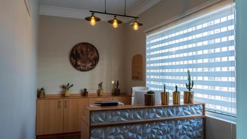 Cette chambre dispose d'une grande fenêtre et d'une table avec des plantes. dans l'établissement Hotel La Casona del Desierto, à Huasco