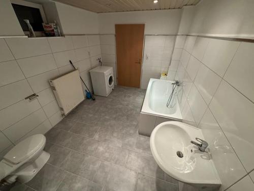 a bathroom with a sink and a toilet and a tub at 2 Schlafzimmer Apartment in Euratsfeld