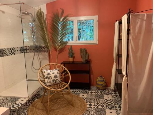 La salle de bains est pourvue d'une chaise, d'une douche et d'une fenêtre. dans l'établissement La villa Pausa en Drôme provençale, à Montboucher-sur-Jabron