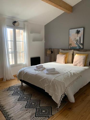 une chambre avec un grand lit et une grande fenêtre dans l'établissement La villa Pausa en Drôme provençale, à Montboucher-sur-Jabron