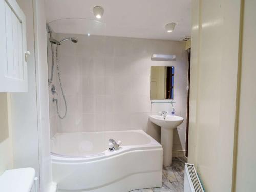 a white bathroom with a tub and a sink at 2 Bed in Keswick 86100 in Keswick
