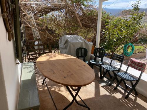 a wooden table and chairs sitting on a porch at Fishermen Beach House in Dhiakofti