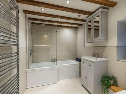 a bathroom with a tub and a shower and a sink at 3 Bed in Wroxham 86387 in Swanton Abbot