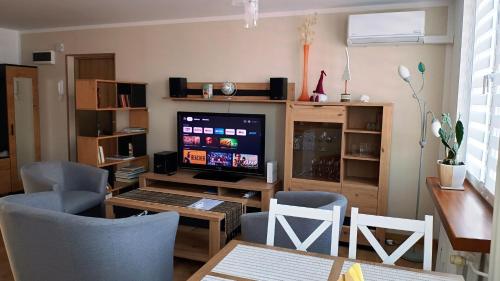 un soggiorno con TV, tavolo e sedie di Apartament Nadstawna klimatyzowany a Biłgoraj