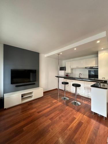 - une grande cuisine avec un comptoir et des tabourets dans l'établissement L'ATHOS - Appartement équipé - Entre Paris et Versailles - Haut débit, à Garches