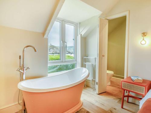 查米斯的住宿－1 Bed in Charmouth 87528，浴室设有橙色浴缸,浴室设有窗户
