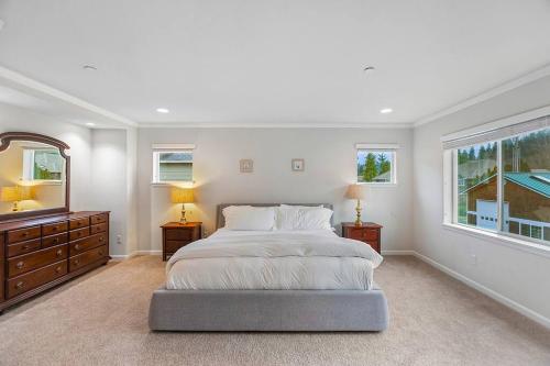 a white bedroom with a large bed and a mirror at Serenity Shores in Kenmore in Kenmore