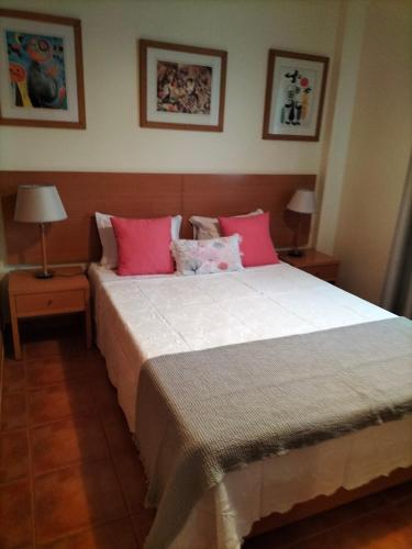 um quarto com uma cama grande e almofadas cor-de-rosa em Apartamento Alagoa Azul em Altura