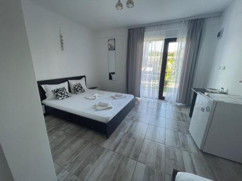 a bedroom with a bed and a wooden floor at CASA SMARALD in Costinesti