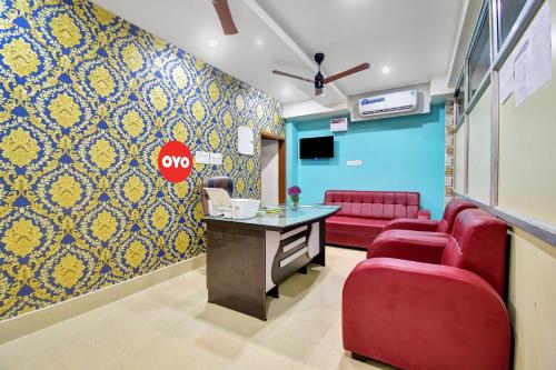 a waiting room with red chairs and a table at SPOT ON Lewis Paradise in Bhubaneshwar