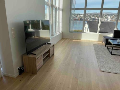 a living room with a large flat screen tv at Fantastisk utsikt, nært sentrum in Tromsø