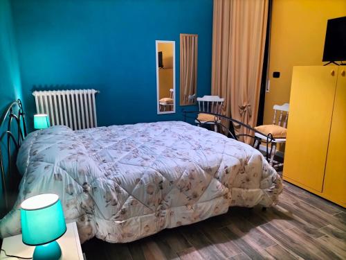 a bedroom with a bed and a blue wall at SWEET HOME alternativo all'appartamento in Pescara