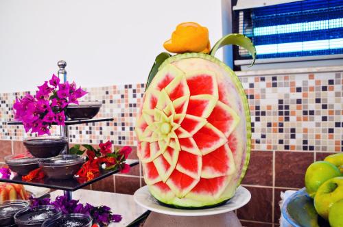 a large watermelon pitcher on a counter with flowers at Belkon Hotel in Belek