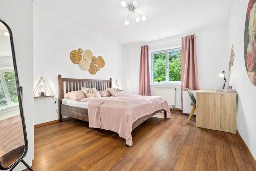 1 dormitorio con cama, escritorio y ventana en Ruhiges Apartment in der Nähe von Park und Krankenhaus mit gratis Parkplatz en Graz