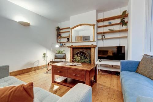 a living room with a fireplace and a blue couch at Henley Street Townhouse in Oxford