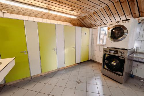 a laundry room with a washing machine and a washer at Trekkershut De Tulpenweide in Breezand
