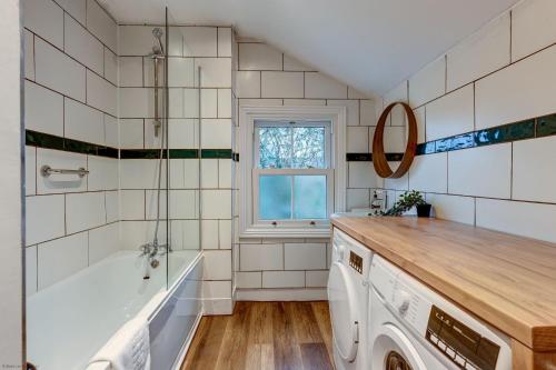 ein Badezimmer mit einer Badewanne und einem Waschbecken in der Unterkunft Henley Street Townhouse in Oxford