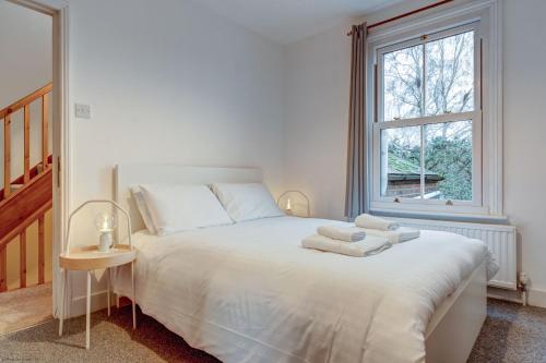 Un dormitorio con una cama blanca con toallas. en Henley Street Townhouse, en Oxford