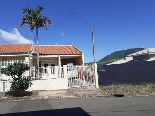 uma casa com uma cerca branca e uma palmeira em Casa próxima ao centro em Monte Sião