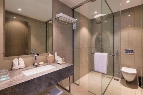 a bathroom with a shower and a sink and a toilet at Hanza Tower 2BDR with Sauna & Jacuzzi & Pool in Szczecin