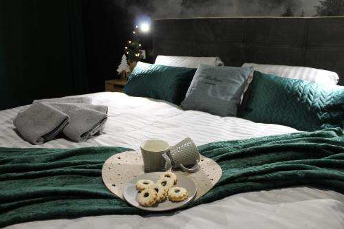 een dienblad met donuts en een kopje koffie op een bed bij Hellene Snow Starý Smokovec in Stary Smokovec