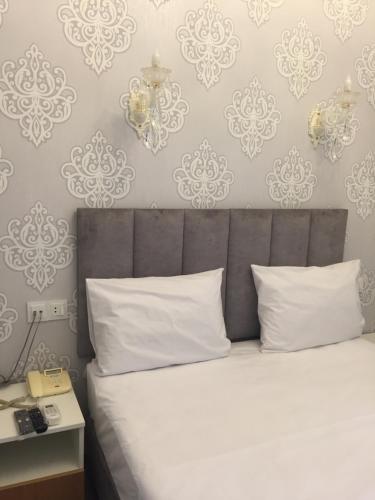 a bedroom with a bed with white pillows and wallpapers at Baku Parks in Baku