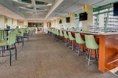 a bar with green chairs in a restaurant at Emerald Beach by Panhandle Getaways in Panama City Beach