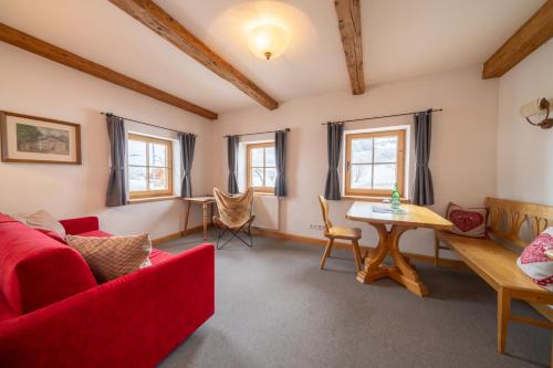 a living room with a red couch and a table at Gasthof Auwirt in Aurach bei Kitzbuhel