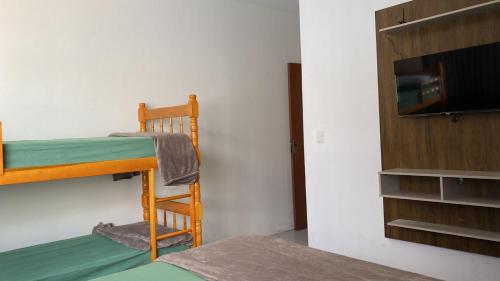 Pokój z 2 łóżkami piętrowymi i telewizorem z płaskim ekranem w obiekcie Pousada Ferreira w mieście São Gabriel