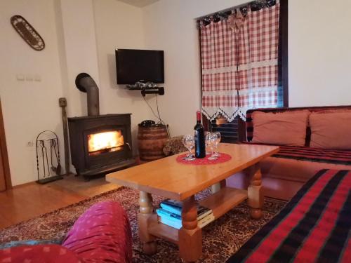 een woonkamer met een tafel en een open haard bij Vikendica Cican Jahorina in Jahorina