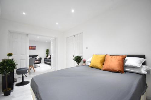 una camera da letto con un grande letto con cuscini colorati di Superb Garden Apartment a Londra