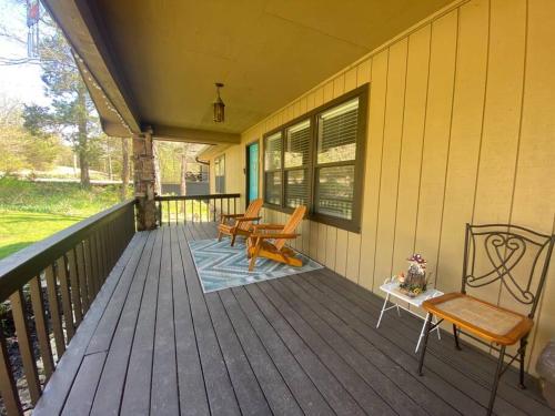 a porch with two chairs and a table on it at Secluded Lakeview retreat by Eureka Springs-CANOE in Eureka Springs