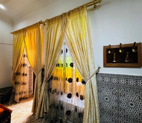Habitación con cortinas en una habitación con pared en Dar Al Fassia, en Oujda