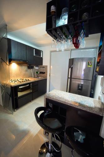 a kitchen with a counter and a refrigerator at Apartamentos Amoblados Confort Turismo en Cúcuta in Cúcuta