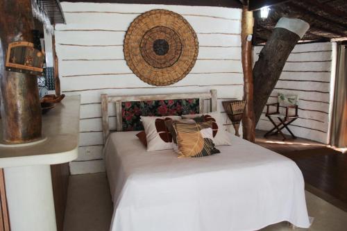 a bedroom with a bed with white sheets and pillows at Villa Maria Bonita in Pipa