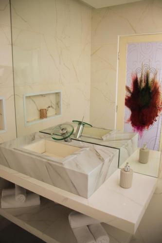 a white bathroom with a tub and a mirror at Villa Maria Bonita in Pipa
