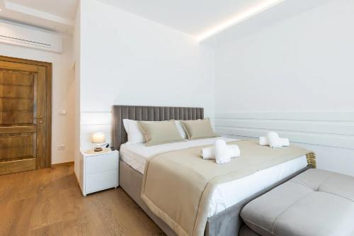 a white bedroom with a large bed and a chair at Villa Florale in Široka