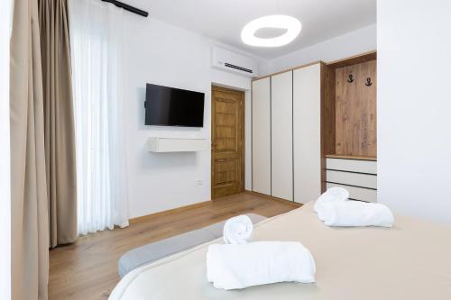 two white beds in a room with a tv at Villa Florale in Široka