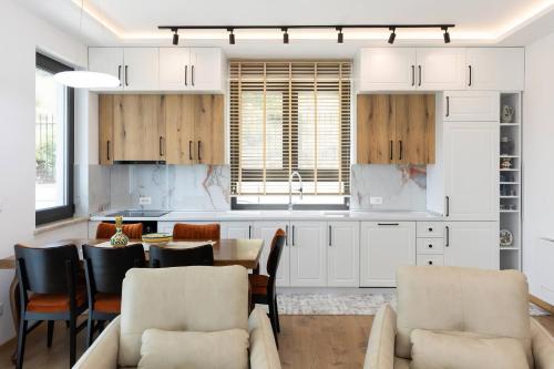 a kitchen with white cabinets and a table and chairs at Villa Florale in Široka