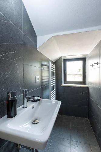 a bathroom with a white sink and a window at Villa Florale in Široka