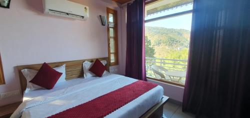 a bedroom with a bed with a view of a balcony at Wonderful Homestay in Kasauli
