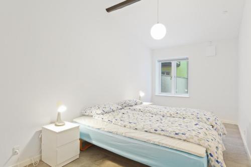 una camera bianca con un letto e una finestra di Come Stay - Charming Oasis in The Heart of Aalborg ad Aalborg