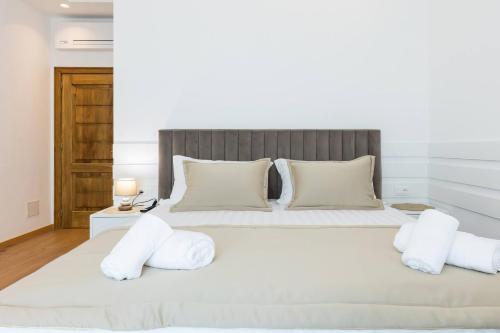 a bedroom with a large white bed with white pillows at Villa Florale in Široka