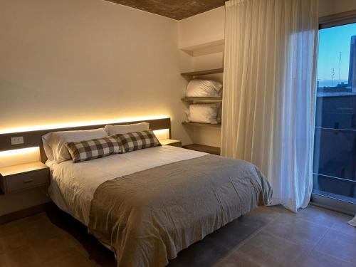 1 dormitorio con cama y ventana grande en Rentarte en Pilar