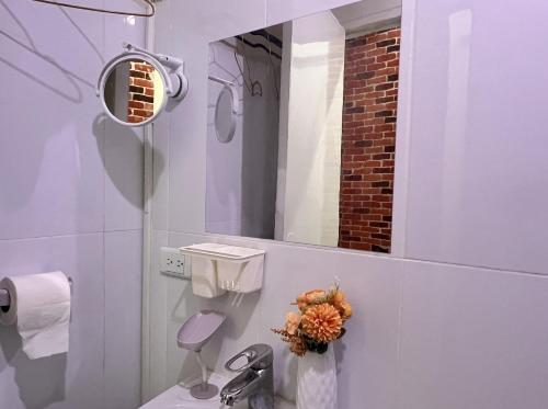 a white bathroom with a toilet and a mirror at Tomas Morato Quezon City - Residences in Manila