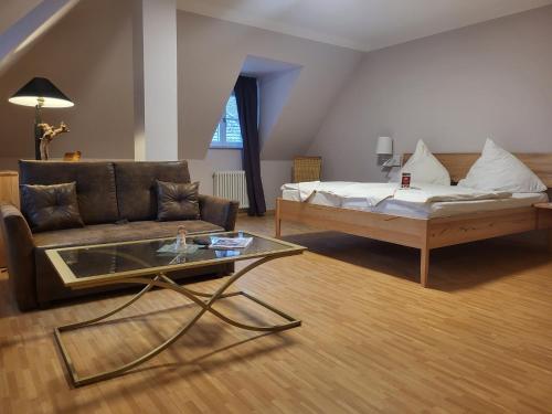 ein Wohnzimmer mit einem Sofa und einem Couchtisch in der Unterkunft Hotel & Café Ritter von Böhl in Deidesheim