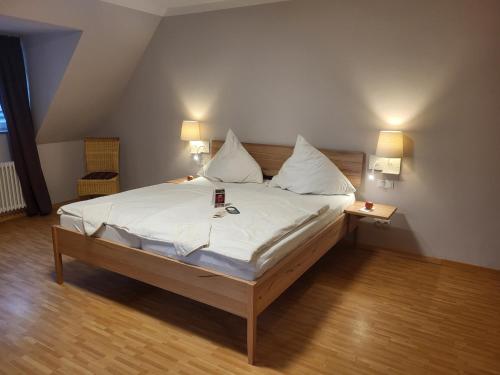 um quarto com uma cama grande com lençóis brancos e almofadas em Hotel & Café Ritter von Böhl em Deidesheim
