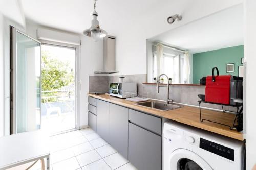 une cuisine avec un évier et une machine à laver dans l'établissement Beautiful apartment with terrace + private parking, à Toulouse