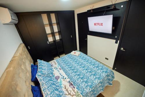 a room with a bed and a tv and a door at Apartamentos Amoblados Confort Turismo en Cúcuta in Cúcuta